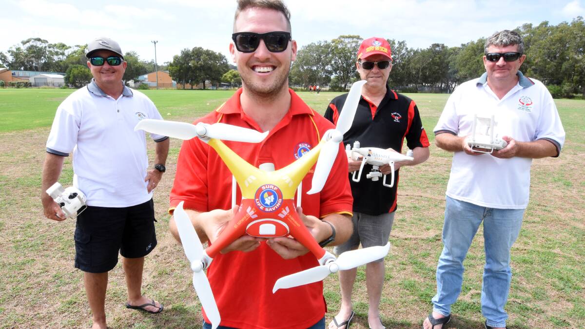 Director of Life Saving for the Lower North Coast Branch Nathan De Rooy holds the new rescue drone while lifeguards (L to R) Brendan Pieschel, Bruce White and Alan Bawden look on.
