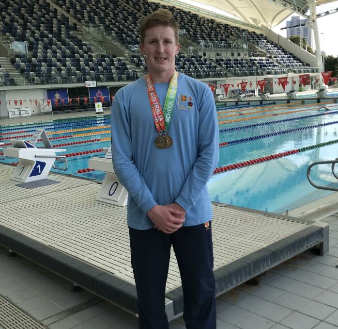 Nash Wilkes with the two gold medals he won at the School Sports Australia Swimming Championships in Melbourne.