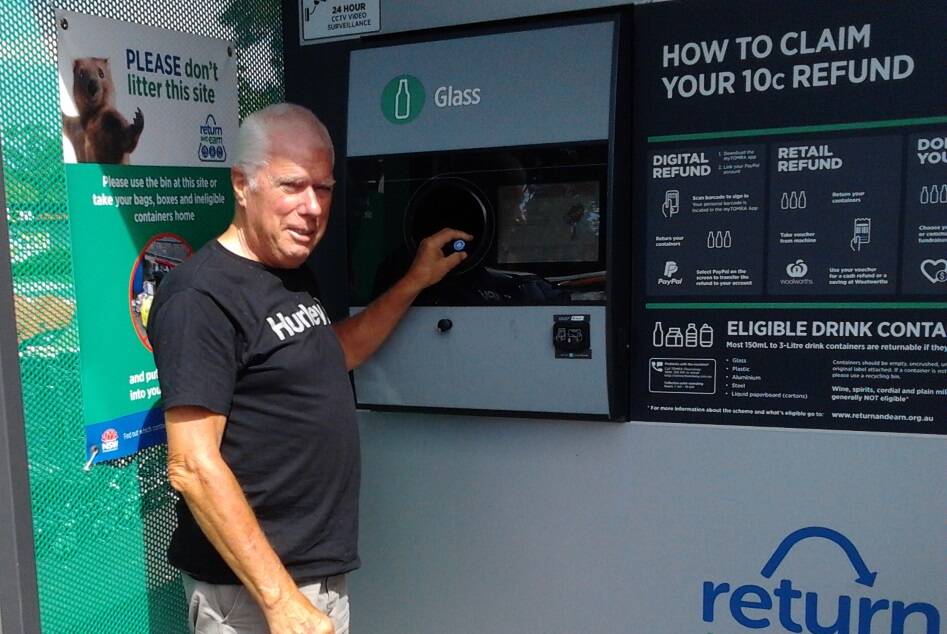 Great Lakes Women's Shelter treasurer, John English at the return and earn vending machine.