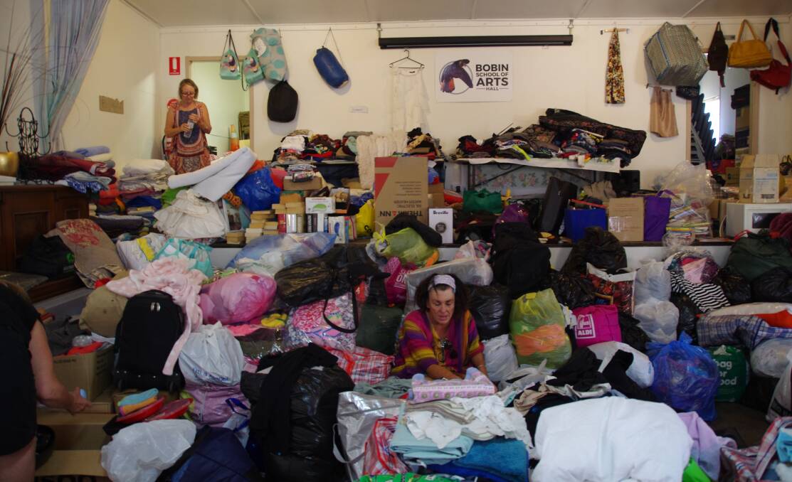 A sea of clothes: volunteers at Bobin hall sort the clothes from the Shell Harbour donation. 