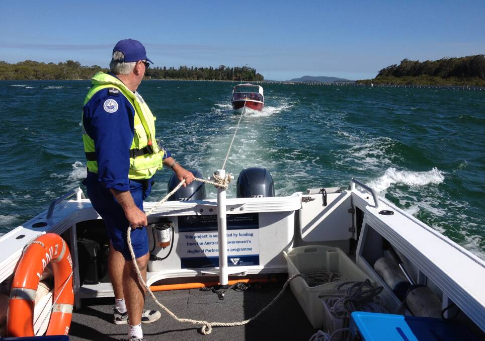 BACK TO SAFETY: Marine Rescue Forster Tuncurry’s leading crew Gary Dickson assists with the tow of a boat carrying a man and three teenagers after they became stranded on Wallis Lake when their boat failed to start.  