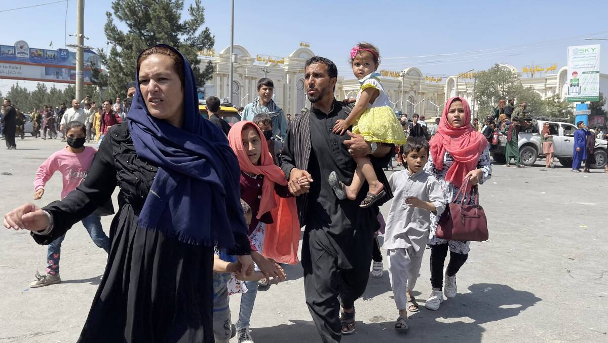 An Afghan family rushes to flee Kabul on Monday as the Taliban arrive in the capital. Picture: Getty Images