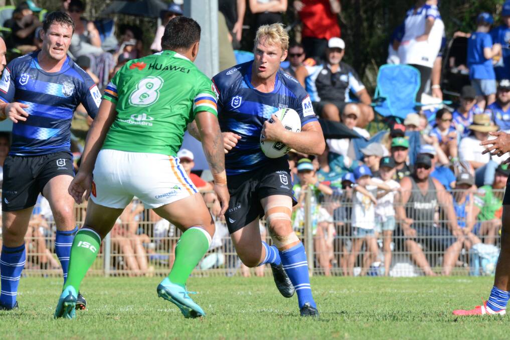 Pre-season hit out: Hat Head's Aiden Tolman charges at Raiders forward Josh Papalii in the Bulldogs NRL trial loss at Port Macquarie. 