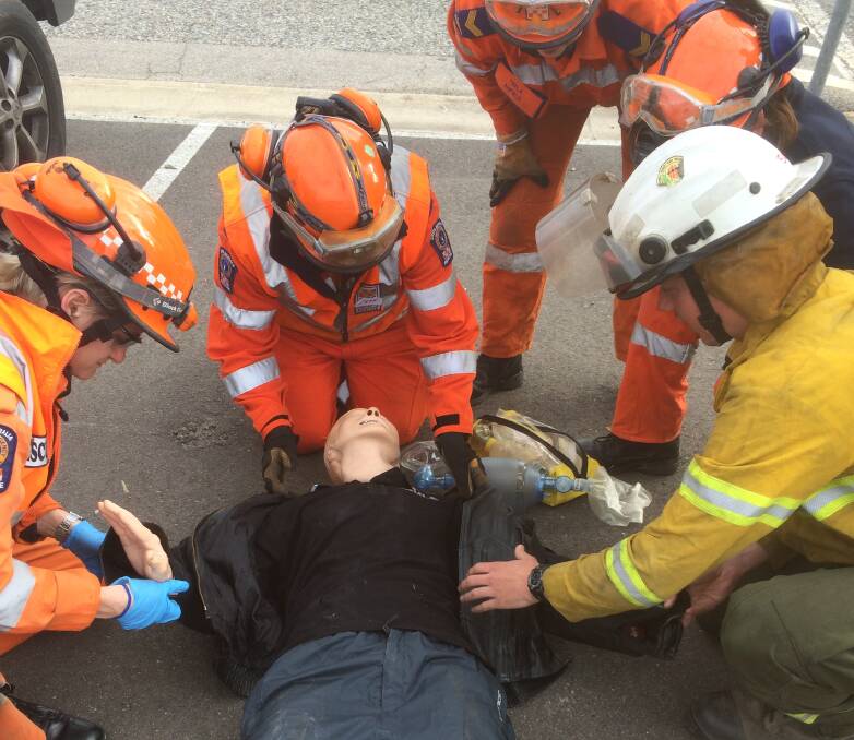 First responders from different organisations work together to help a 'driver' after an accident.
