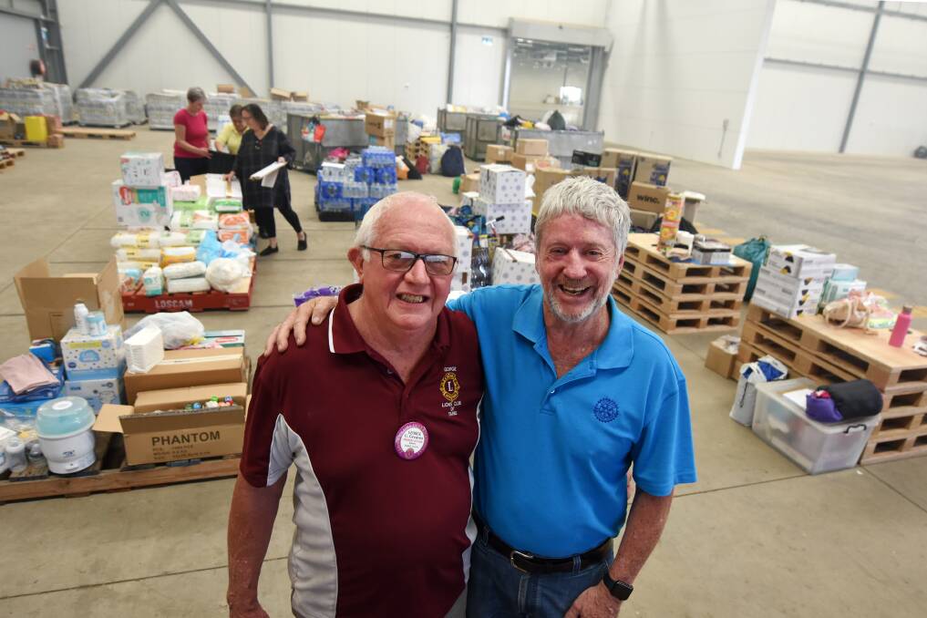 Working together: Taree Lions Club president George Greaves and Rotary Club of Taree on Manning projects manager Maurie Stack at the relief centre. Photo: Scott Calvin.