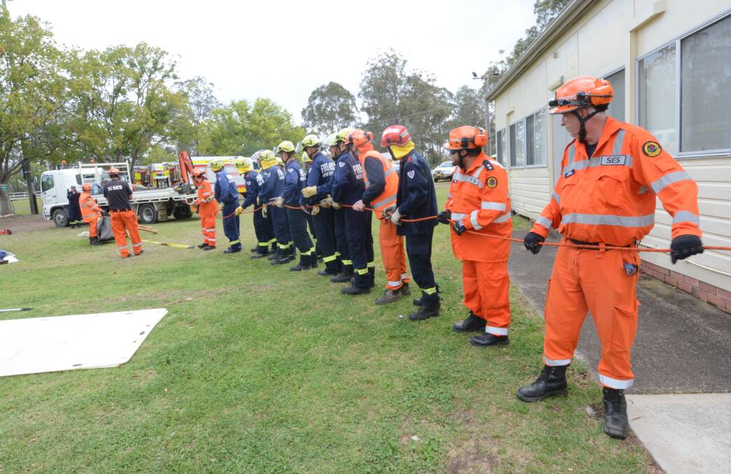 Fire and Rescue NSW and State Emergency Service personnel practice a pulling apparatus.