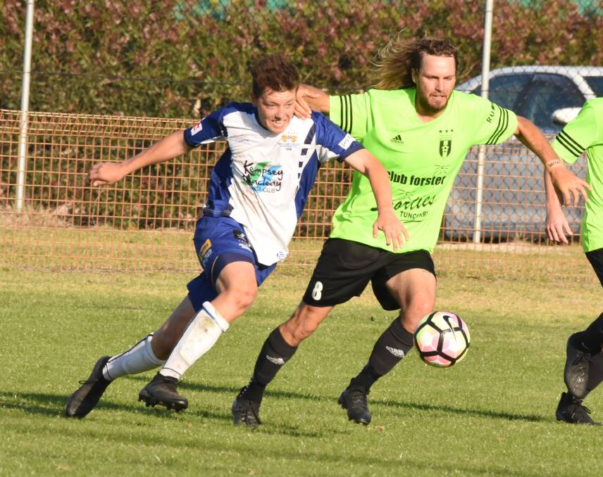 Thrilling contest: Macleay Valley's Daniel Saul and Wallis Lake captain Beau Wynter battle for the ball. The Rangers won the first grade grand final 5-3 in extra time. Photo: Scott Calvin. 