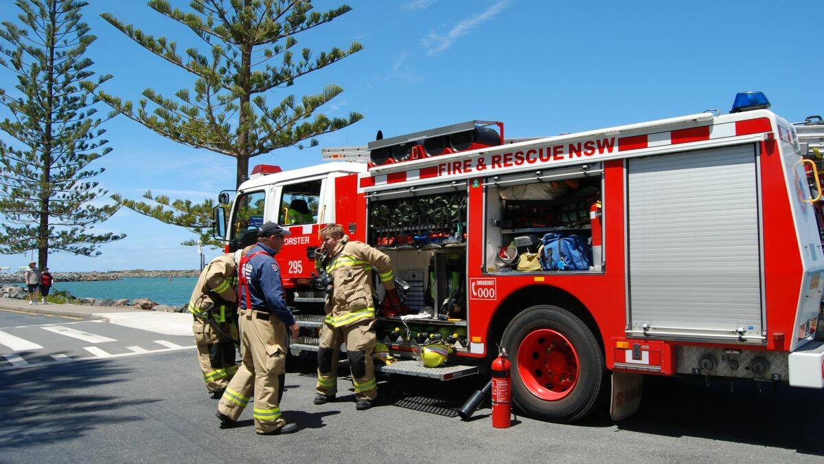 SAFETY CHECK: Fire crews prepare to inspect the cruiser Restless which had to be towed back into Tuncurry this afternoon. 