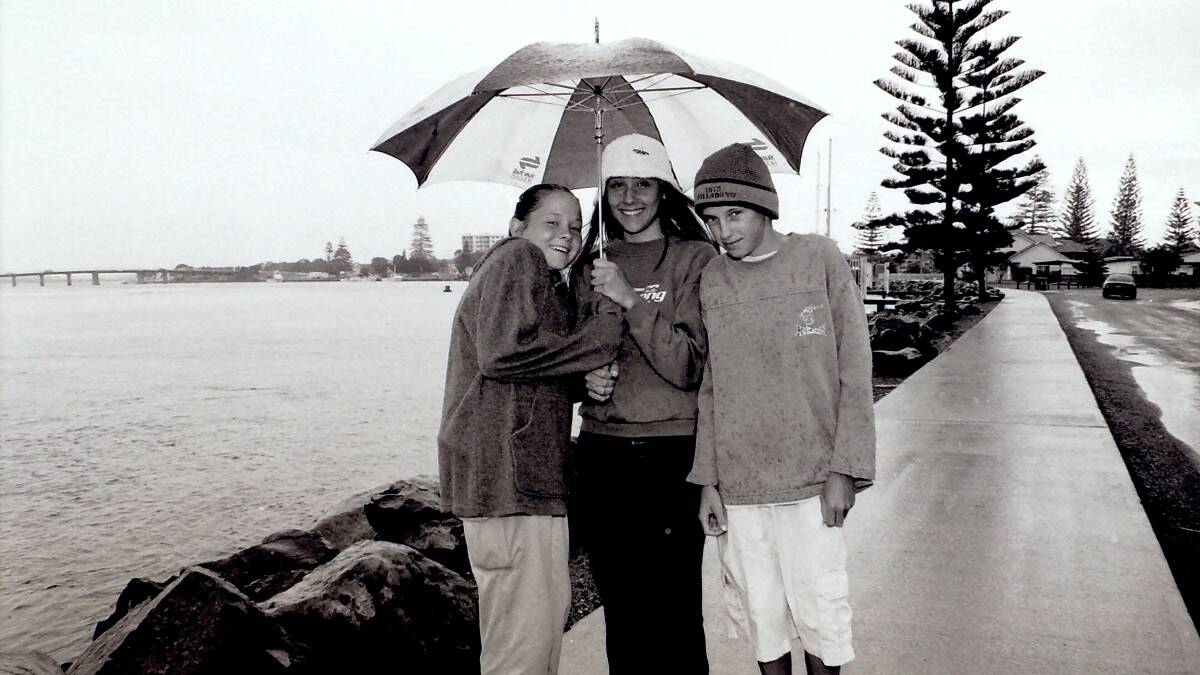 THROWBACK THURSDAY: Joanne Goodridge and Ebony Cassin from Sydney with David Graham from Newcastle didn't let the rain stop them from getting out and about in Tuncurry. 