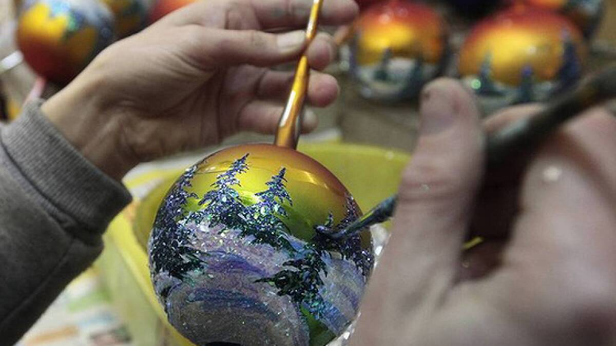 An employee hand paints glass Christmas and New Year decorations at the 'Biryusinka' toy factory in Russia's Siberian city of Krasnoyarsk. Photo: REUTERS